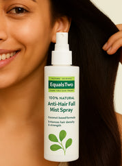 Woman holding a bottle of Equals Two Anti-Hair Fall Mist Spray with a neutral background