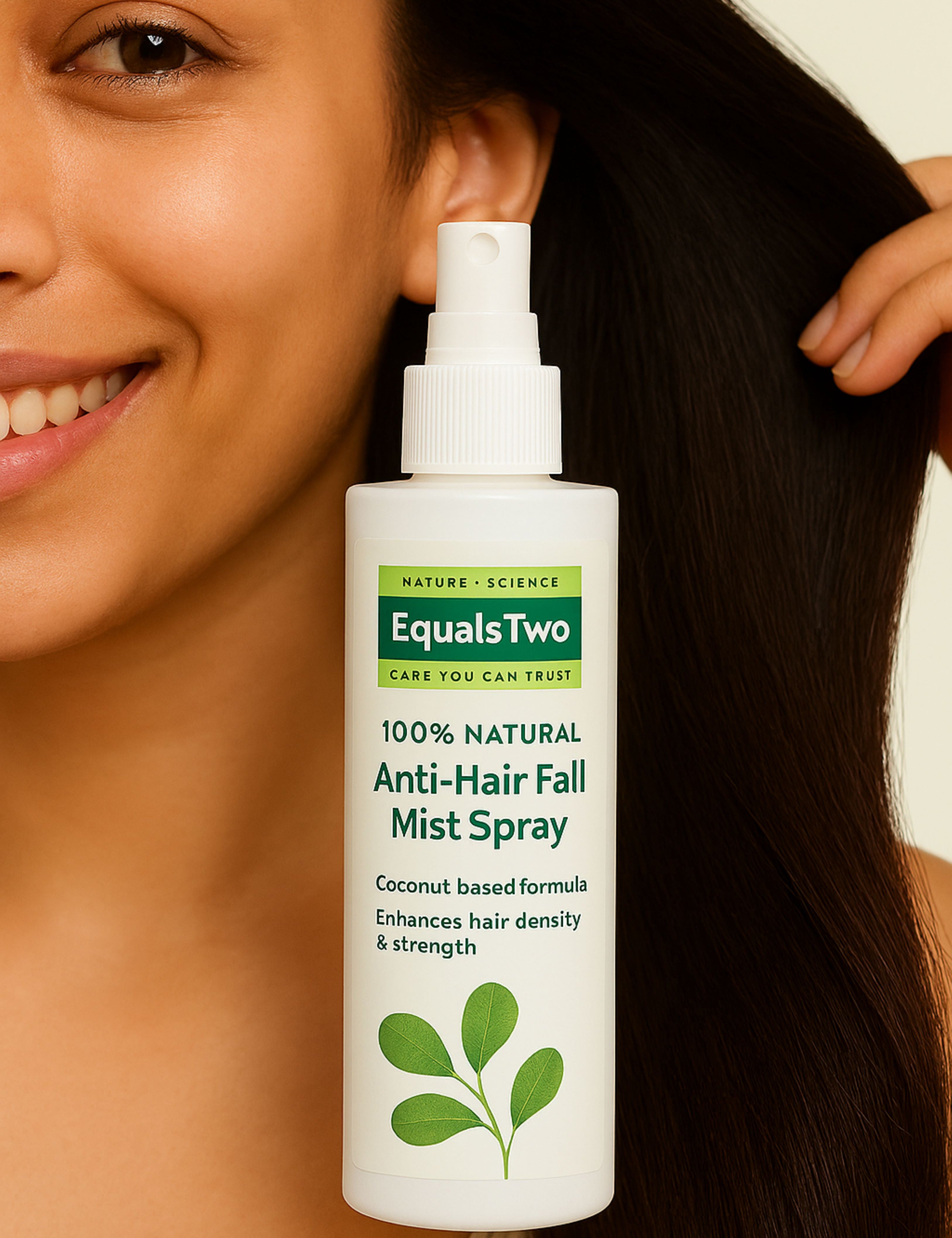 Woman holding a bottle of Equals Two Anti-Hair Fall Mist Spray with a neutral background