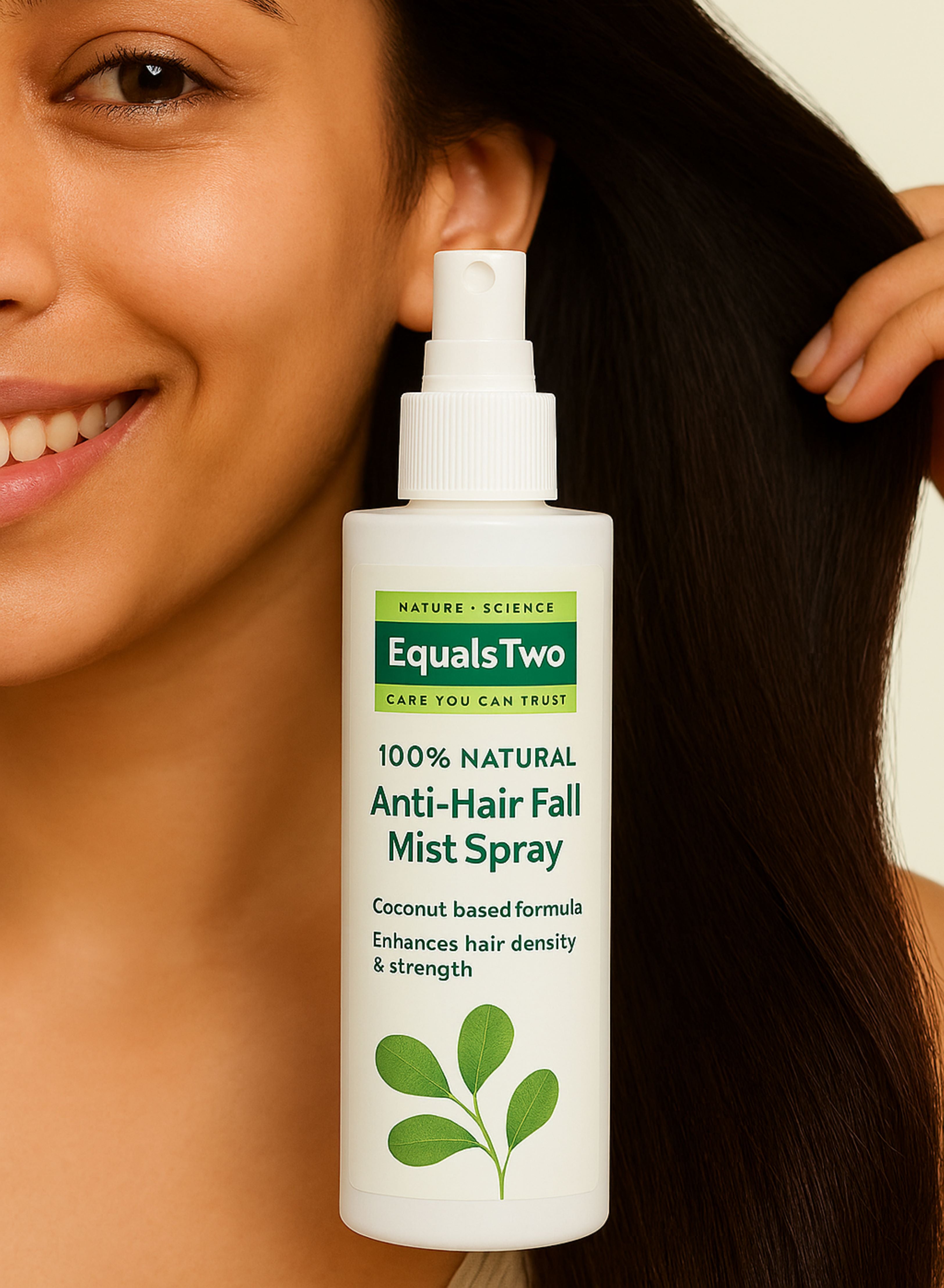 Woman holding a bottle of Equals Two Anti-Hair Fall Mist Spray with a neutral background